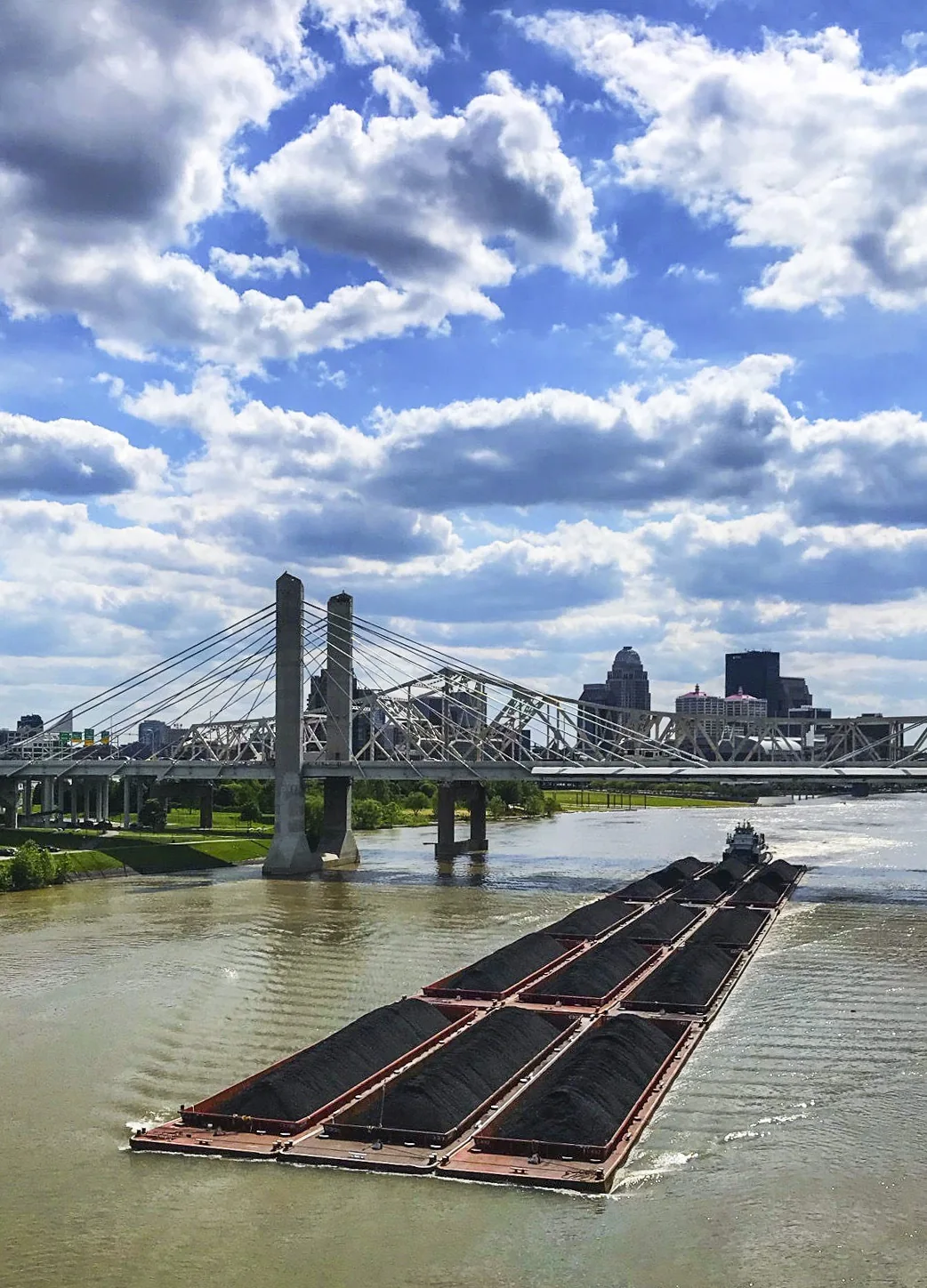 Barge moving along the Ohio River with Louisville beyond